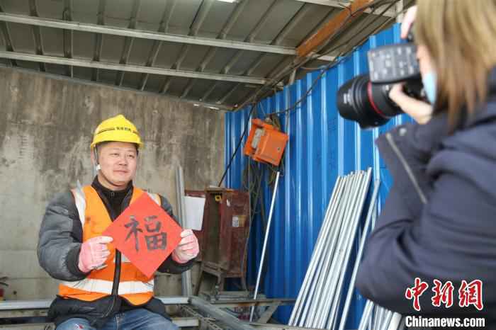 上海共青团全城展开关心关爱春节留沪青少年集中行动。在北外滩的一个在建重大工程工地,一支青年摄影师组成志愿者队伍,为工地青年拍摄照片、送去春联。上海团市委供图 上海共青团全城展开关心关爱春节留沪青少年集中行动。在北外滩的一个在建重大工程工地,一支青年摄影师组成志愿者队伍,为工地青年拍摄照片、送去春联。上海团市委供图