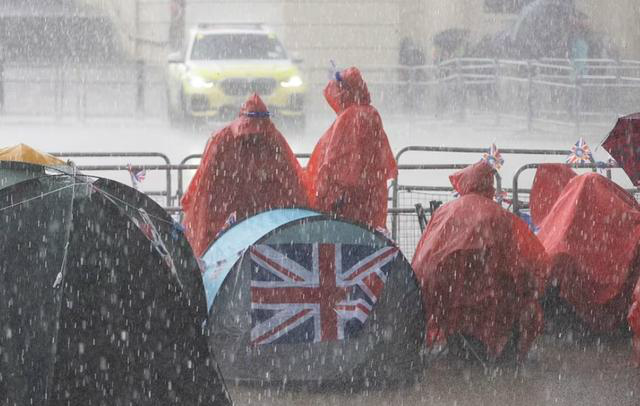 伦敦将迎暴雨 民众披雨衣街头露营 抢占最佳位置
