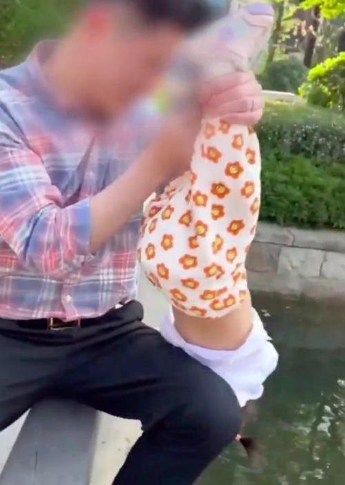 90后宝爸拽脚倒提1岁女儿摸金鱼 网友：出意外了谁负责？
