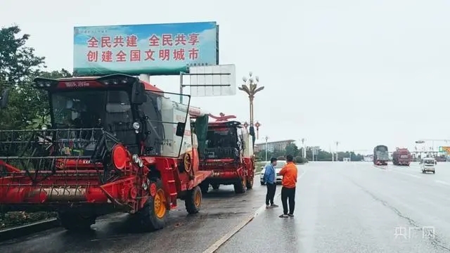 唐河县高速收费站附近，焦作收割机手韩凯正在考虑下步行程（央广网发程海舟摄）.webp